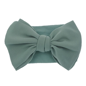 Elastic baby headband featuring a large dark green bow with textured fabric finish