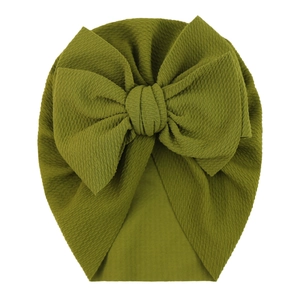 Detailed close-up of grass green waffle fabric baby turban with a large decorative bow