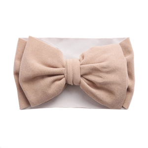 Vue détaillée du bandeau souple pour bébé en nylon extensible avec un grand nœud en beige