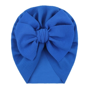 Detail of royal blue baby turban hat with textured bubble fabric and large bow decoration