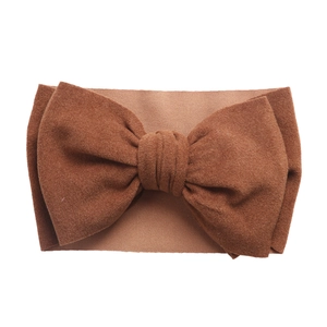 Détail d'un bandeau élastique doux pour bébé avec un grand nœud papillon marron foncé