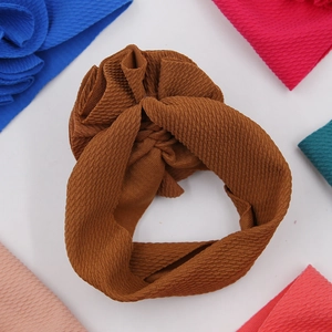 Bandeau bébé marron texture gaufre avec fleur entouré de plusieurs options de couleurs