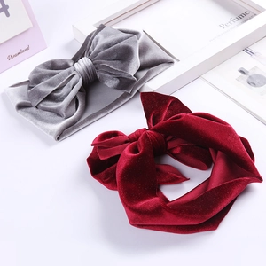 Detail of plush velvet baby headbands with large bows in grey and burgundy colors