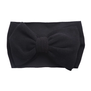 Détail d'un bandeau pour bébé en tissu noir doux et élastique avec grand nœud