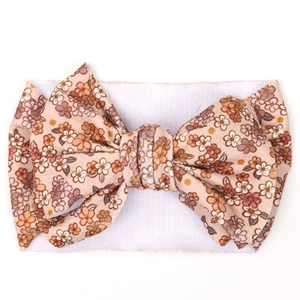 Detailed macro view of vintage floral bow fabric and white elastic baby headband