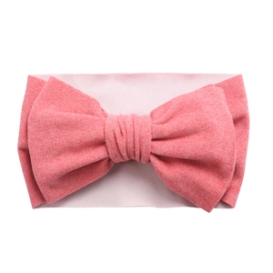 Gros plan sur un bandeau de bébé en tricot corail doux avec un grand nœud papillon
