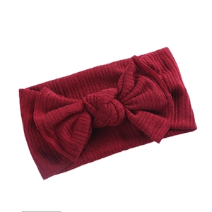 Nahaufnahme der gerippten Strickstruktur auf einem dunkelroten Schleifen-Stirnband