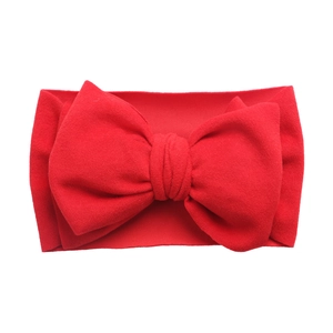 Vue détaillée d'un grand bandeau de bébé rouge avec nœud en tissu tricoté souple