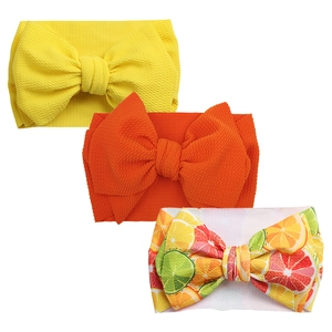 Three-piece baby bow headband set with yellow, orange, and citrus fruit print patterns