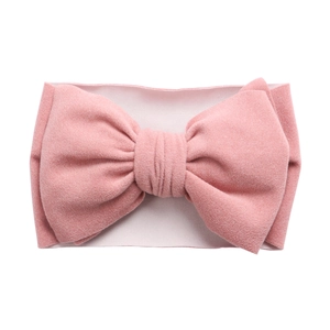 Vue détaillée du bandeau rose à nœud pour bébé avec une texture en nylon doux et extensible
