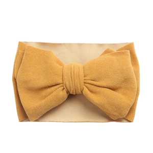 Vue détaillée d'un bandeau à nœud jaune moutarde doux et extensible pour les bébés