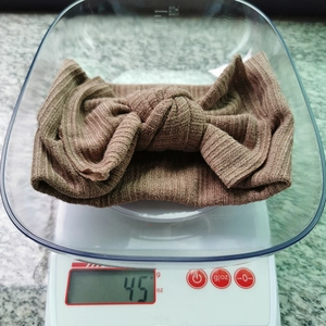 Detail der 45g schweren braunen Strick-Baby-Stirnband mit großer doppellagiger Schleife