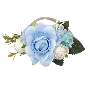 Dettaglio di fiori in tessuto blu e bianco su fascia elastica per neonati con foglie