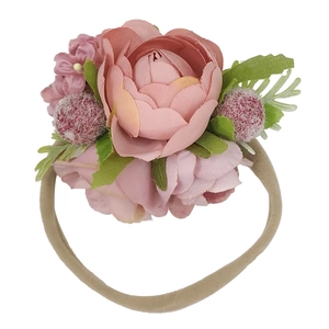 Fascia per neonati con fiori rosa artificiali e nastro in nylon su sfondo bianco