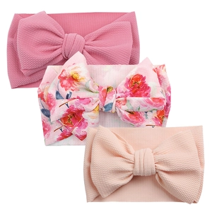 Detailed view of three baby bow headbands featuring waffle knit and floral print fabrics