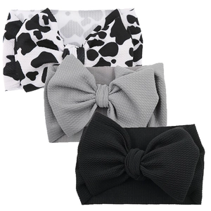 Detailed macro view of three baby headbands with large bows in waffle knit fabric patterns