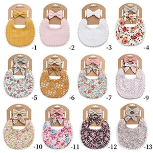 Détails d'un ensemble bavoir bébé et bandeau à nœud avec motifs floraux et à carreaux