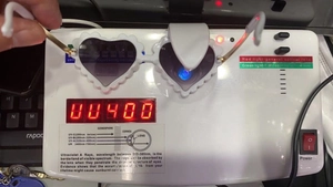 Testing heart-shaped sunglasses showing UV400 protection level on a digital detector