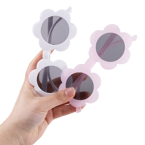 Sunflower shaped kids sunglasses in white and pink colors with round dark grey lenses