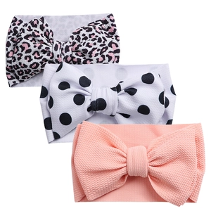 Three-pack baby headbands with leopard print, polka dots, and coral pink oversized bows