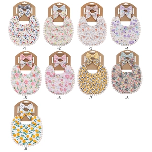 Set of 9 floral baby bibs and matching headbands with decorative white pompoms