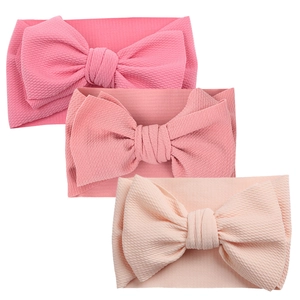 Three-piece baby headband set with large bows and textured ribbed fabric in pink shades