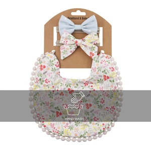 Détail d'un ensemble de bavoirs pour bébé avec imprimé floral et bandeaux à nœuds assortis
