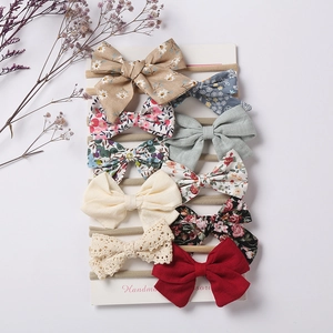 Set of 10 handmade baby nylon headbands with floral and solid color bows on a card