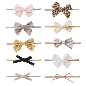 Detail of 10-piece baby headband set with various fabric bows and nylon bands