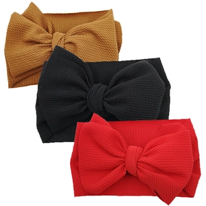Three-piece baby headband set with large bows and ribbed knit texture in yellow black and red