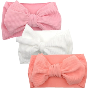 Three-piece baby headband set with large bows in pink and white waffle knit fabric