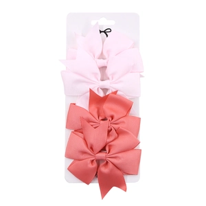 Detalle de 6 lazos para el pelo de cinta de falla en rosa y coral en tarjeta de exhibición