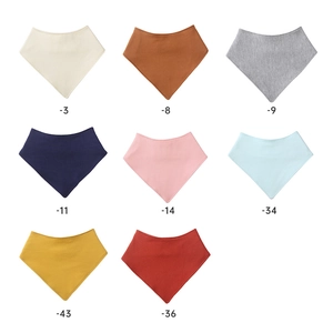 Set of eight solid color cotton baby bandana bibs with snap buttons in various soft shades