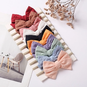 Set of 10 colorful baby bow headbands featuring delicate eyelet embroidery and nylon straps
