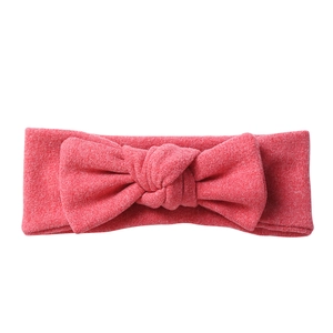 Detailed close-up of soft coral pink bow headband with knitted texture for babies