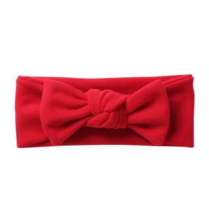 Detailed texture of red cashmere-like knitted bow headband for babies with elastic fabric
