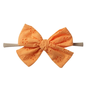 Bright orange eyelet embroidery cotton bow on soft nylon headband for babies