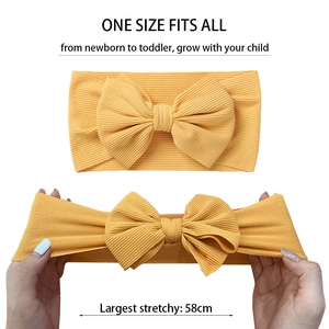 Elastic baby bow headband in bright yellow rib knit showing its high stretch ability