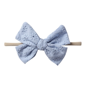 Detailed view of baby headband with light blue floral embroidery and nylon band