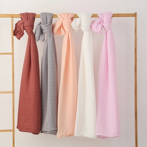 Detail of five-color bamboo cotton swaddle blankets with crinkle texture on wooden rack