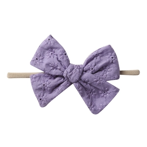 Detailed view of purple floral embroidery on soft nylon baby bow headband