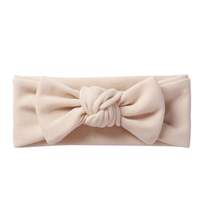 Detail of soft cream baby headband with large cashmere-like bow and knitted texture