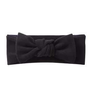 Macro detail of the soft black cashmere-like fabric texture and large bow on baby headband