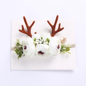 Detail of Christmas reindeer antler headband with white fabric flowers on elastic band