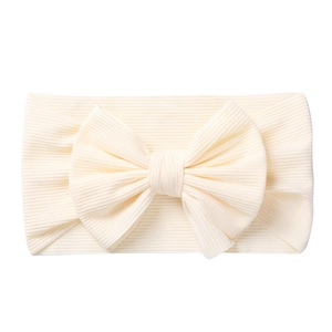 Detail of baby bow headband in cream rib knit fabric with large knot for infants