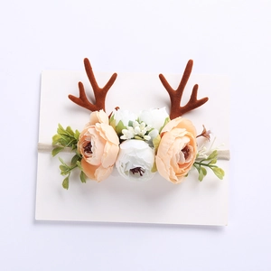 Detail of Christmas reindeer baby headband with realistic flowers and soft nylon strap