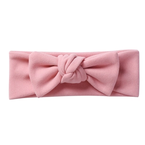 Detailed close-up of soft pink knit baby headband with a decorative bow knot