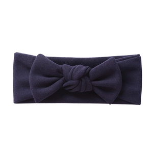 Detail of soft purple knitted baby headband with a large decorative bow on white background