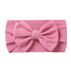 Detail showing the ribbed knit texture and large bow on this pink baby elastic headband