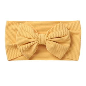 Close-up of ginger yellow knit baby headband showing textured vertical ribbing fabric